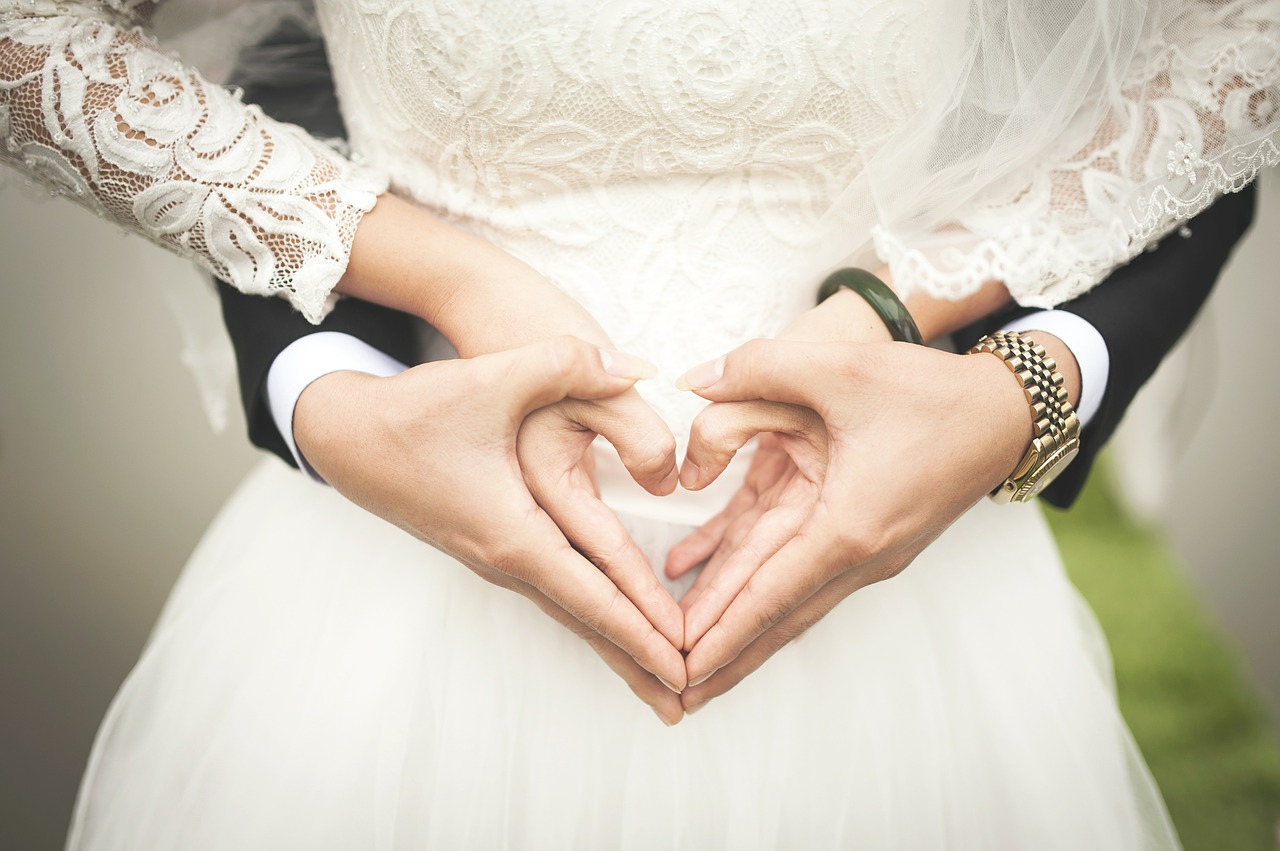 Newlyweds making hand hearts
